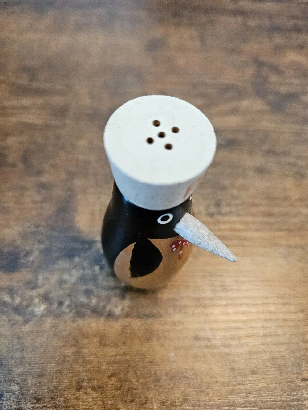Vintage hand-painted wooden pepper shaker shaped like a penguin